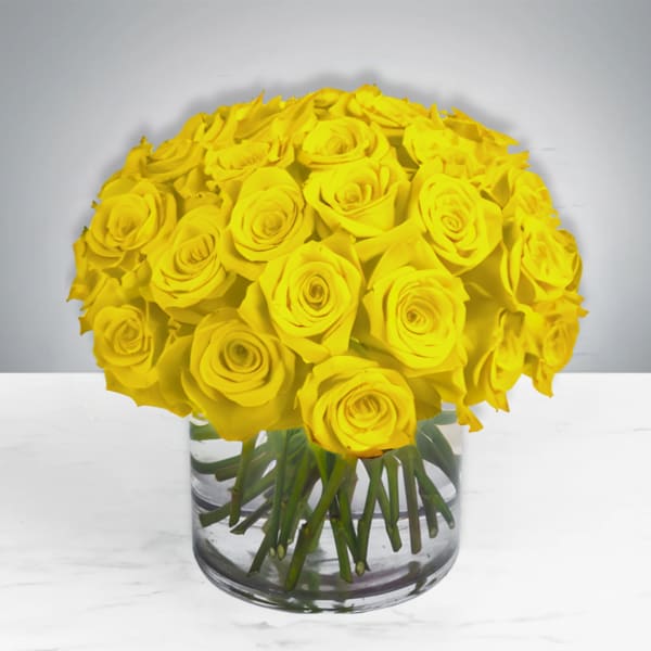 Yellow roses arranged in a clear glass vase