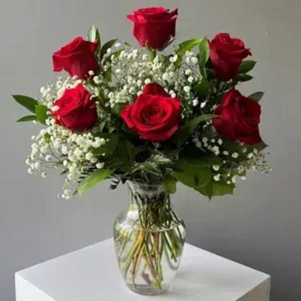 Bouquet of red roses and baby's breath in a clear glass vase