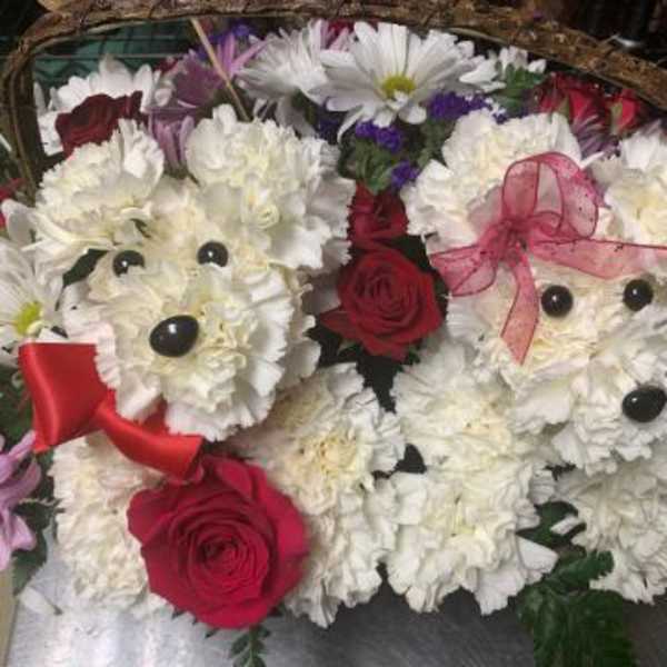 Two teddy bear floral arrangements with red roses and white flowers