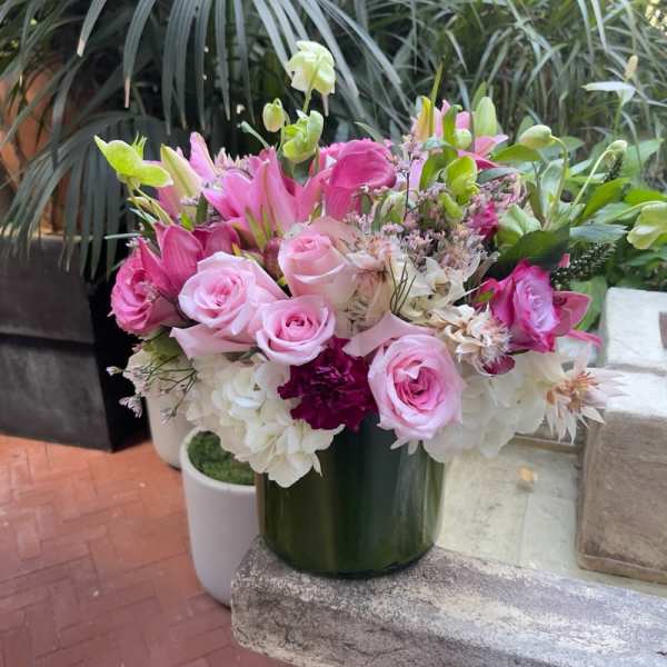 Pink roses and lilies arranged in a green vase