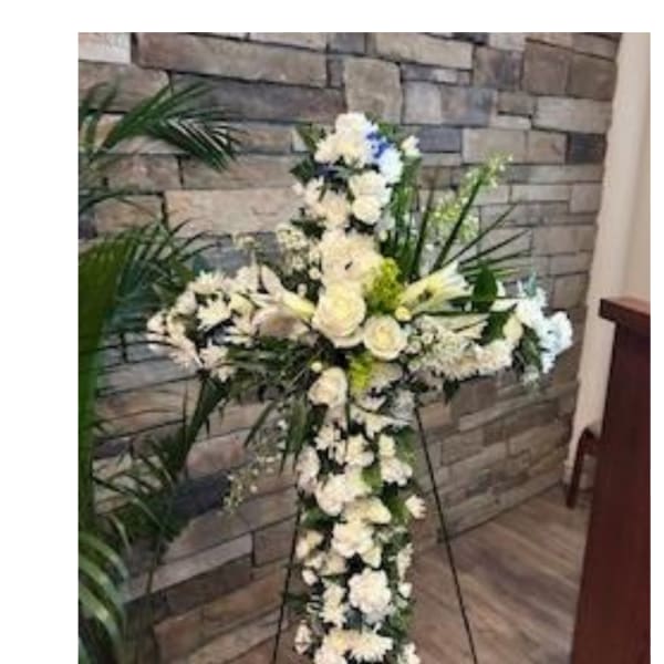 White floral standing cross on an easel