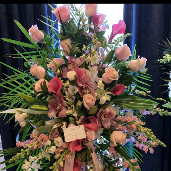 Tall pink and white floral standing arrangement with orchids and roses
