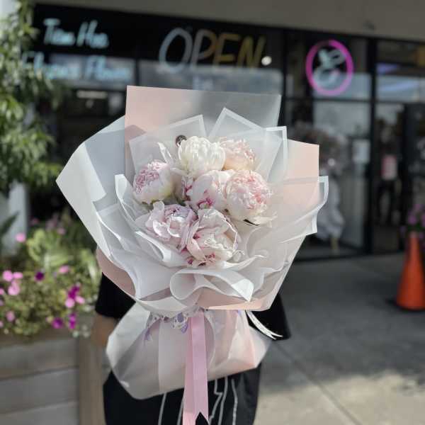 Pink and white peony bouquet wrapped in translucent paper