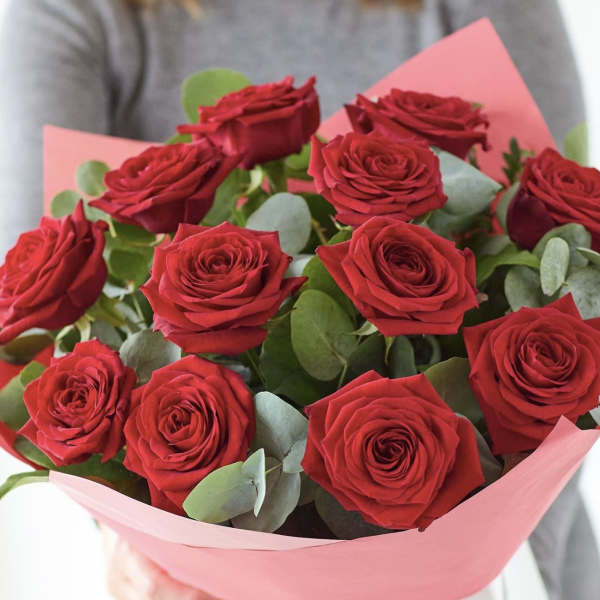 Bouquet of red roses wrapped in pink paper