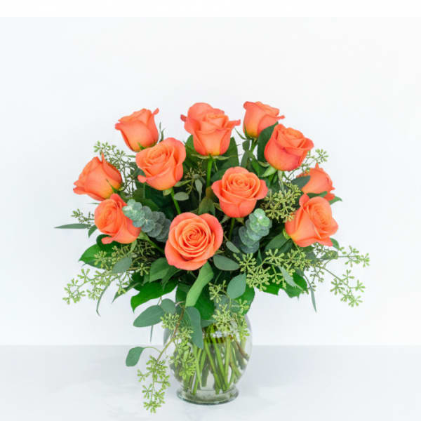 Orange roses arranged in a clear glass vase