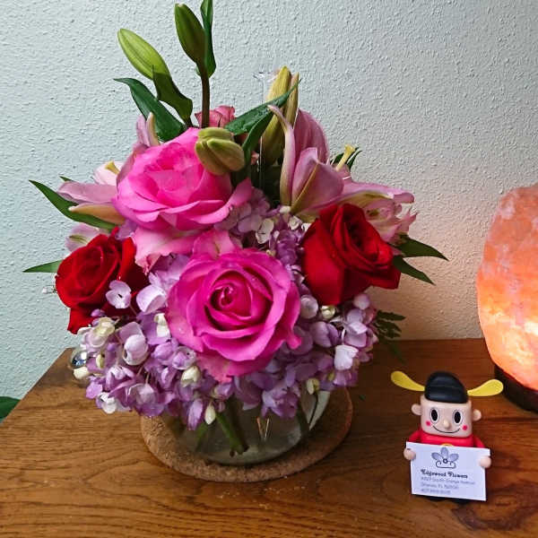 Pink and red roses with lilies in a glass vase