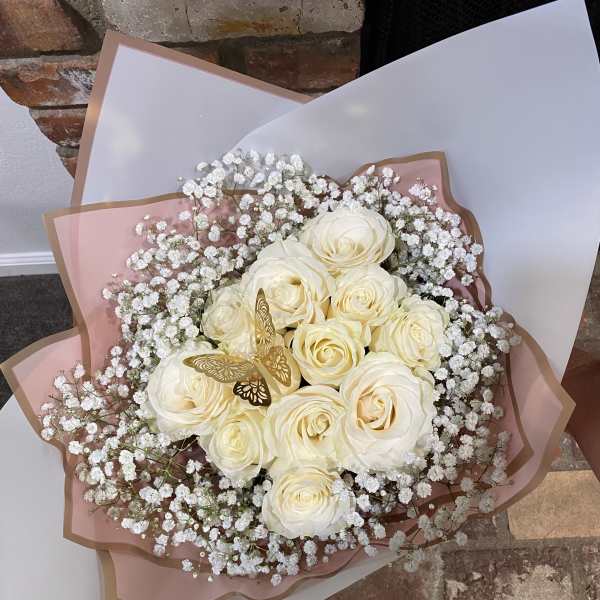Bouquet of white roses with baby's breath in pink and white wrap