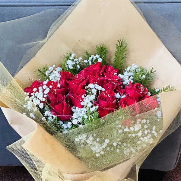Bouquet of red roses with white baby's breath wrapped in beige tulle