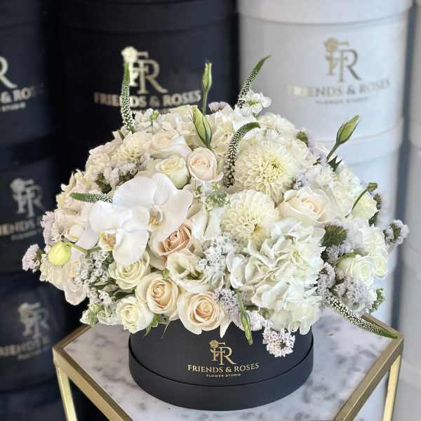 White and blush bouquet in a round black box