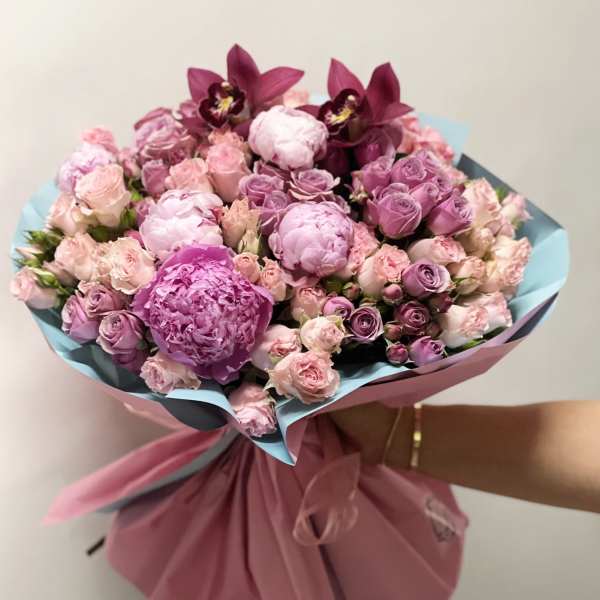 Pink and lavender bouquet with roses and orchids wrapped in paper