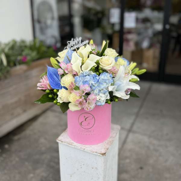 Bouquet of pastel flowers in a pink hat box
