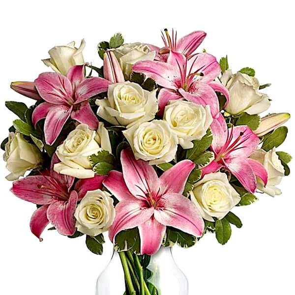 Pink lilies and white roses arranged in a clear glass vase
