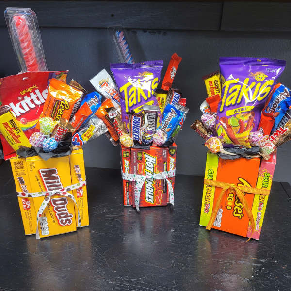 Three candy gift boxes filled with assorted sweets and tied with ribbons