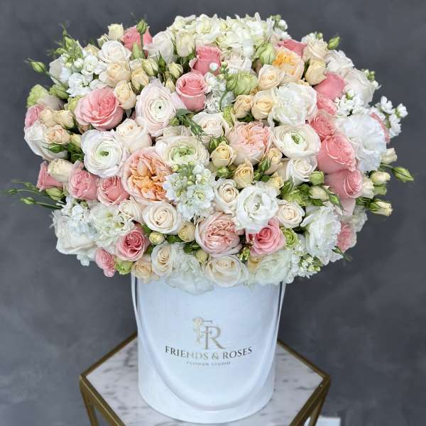 Large pastel bouquet of roses and white blooms in a white hatbox