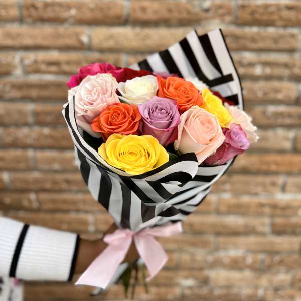 Bouquet of multicolored roses wrapped in black-and-white striped paper