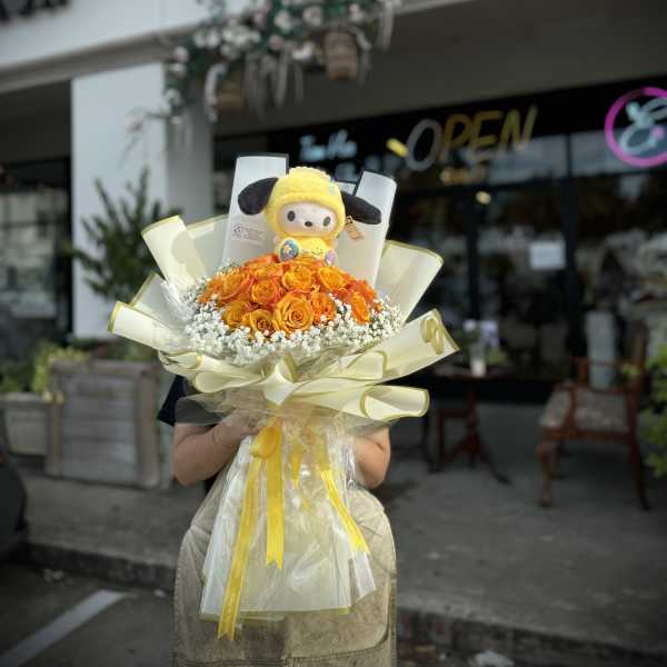 Bouquet of orange roses with a plush character topper