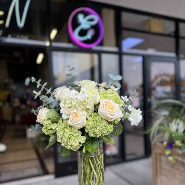 Bouquet of white and pale green flowers in a clear glass vase
