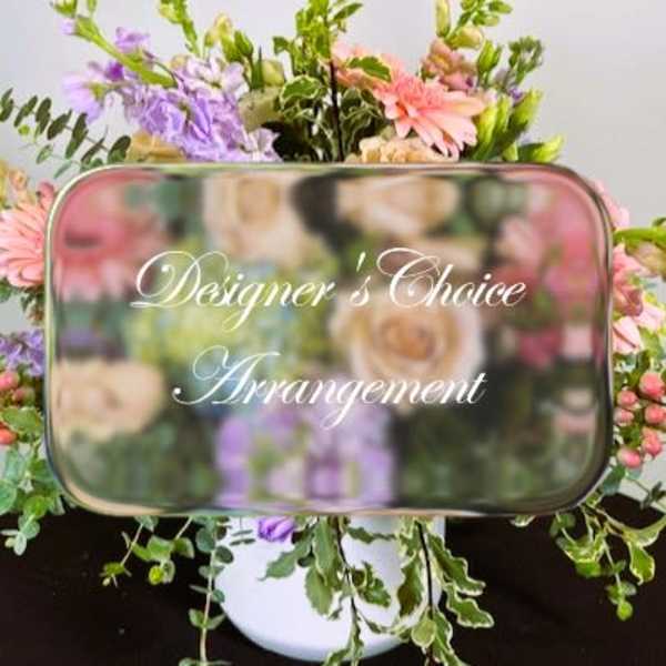 Mixed flower arrangement behind a mirrored sign reading Designer's Choice Arrangement