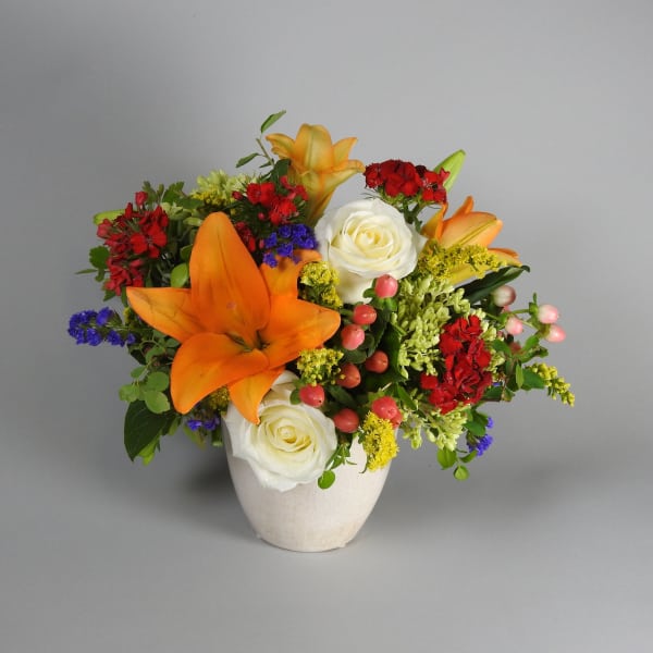 Orange lilies and white roses in a white vase