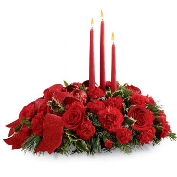 Red floral centerpiece with three lit taper candles