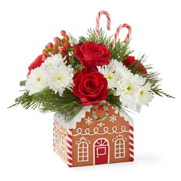 Christmas floral arrangement in a gingerbread house container with roses and white mums