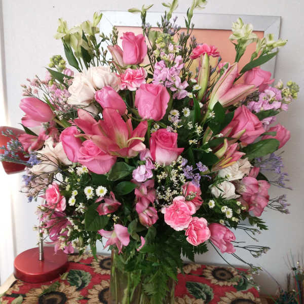 Large pink and white mixed bouquet in a clear glass vase