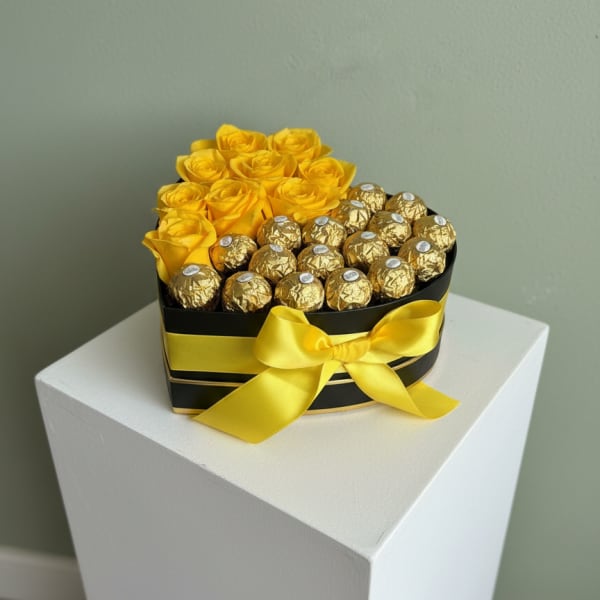 Heart-shaped box with yellow roses and gold-wrapped chocolates tied with a yellow ribbon