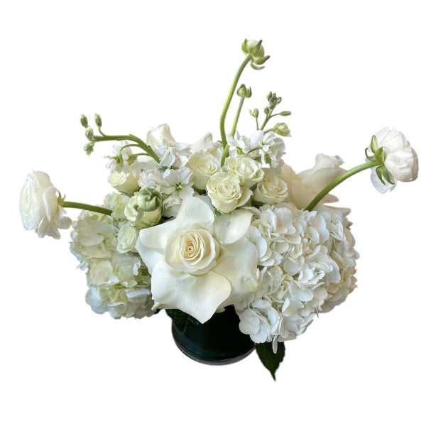 White floral arrangement in a dark vase with roses and hydrangeas