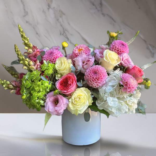Mixed bouquet in a white vase with pink, cream, and white blooms