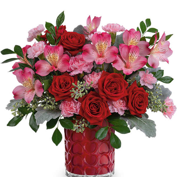Red roses and pink flowers in a red heart-pattern vase