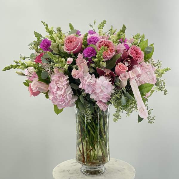 Pink and purple flower arrangement in a clear glass vase