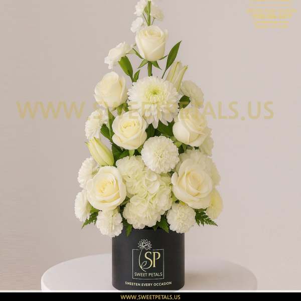 White roses and mums arranged in a black box vase