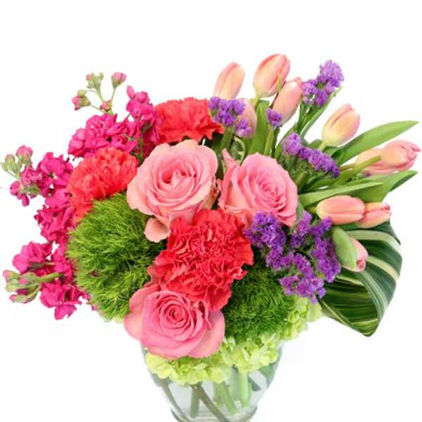 Pink roses, tulips, and purple filler flowers in a glass vase
