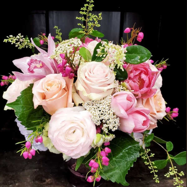 Pink and peach rose bouquet with orchids in a vase