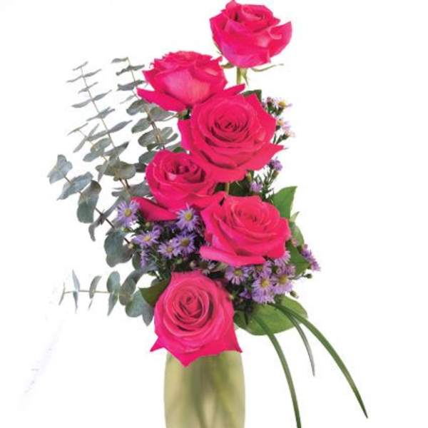 Pink roses arranged in a tall vase with purple filler flowers