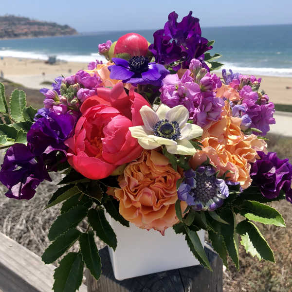 Colorful bouquet of mixed flowers in a white container