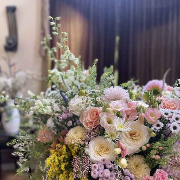 Large pastel flower arrangement in a woven basket