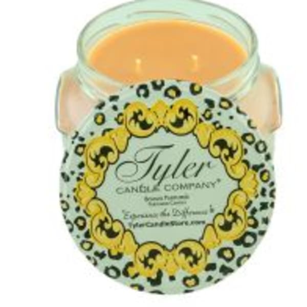 A scented candle in a glass jar with a decorative label.