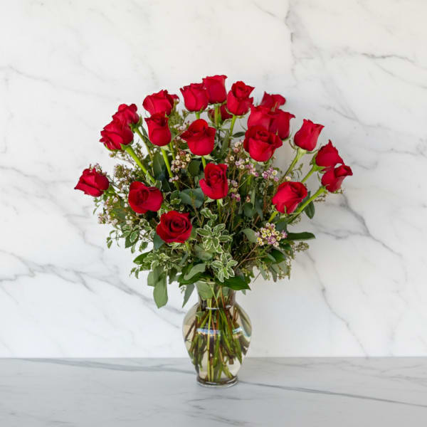 Red roses arranged in a clear glass vase