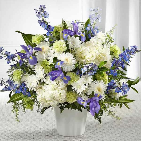 White and purple floral arrangement in a white vase