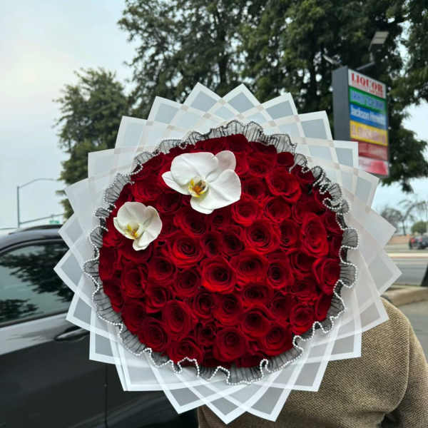 Large round bouquet of red roses with two white orchids