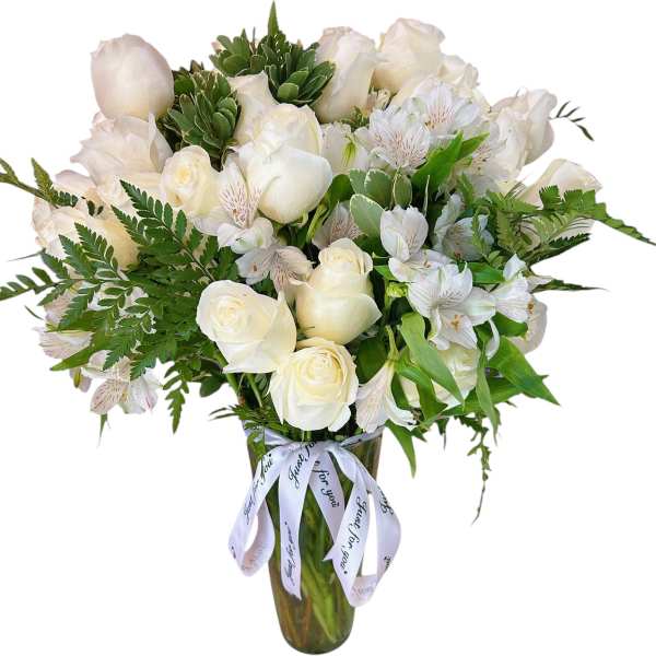 White roses and alstroemeria in a tall glass vase with a ribbon