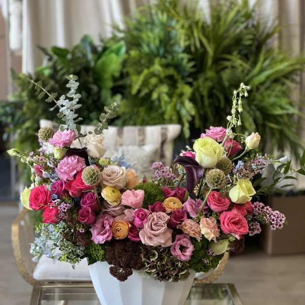 Colorful mixed flower arrangement in a white vase