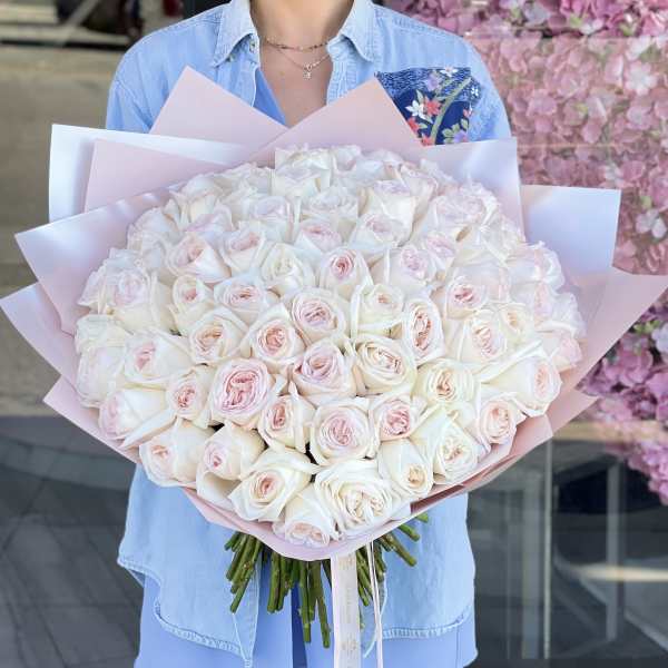 Large bouquet of pale pink and white roses wrapped in pink paper
