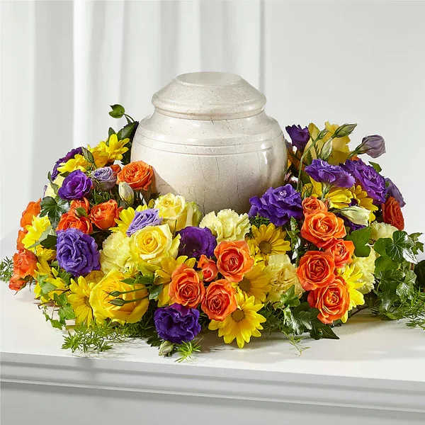 Colorful floral wreath around a white urn