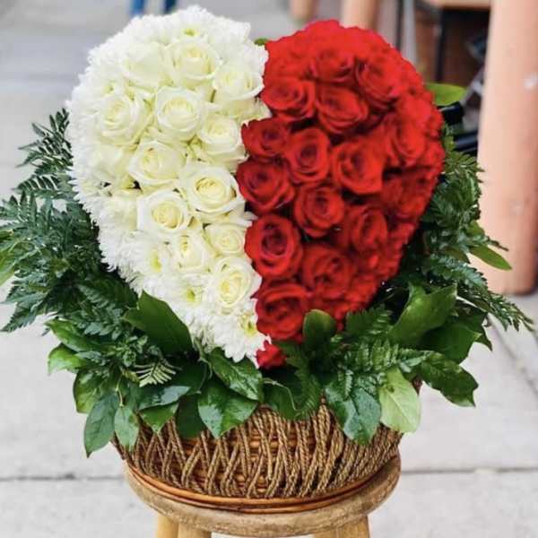 Heart-shaped red and white rose arrangement in a woven basket
