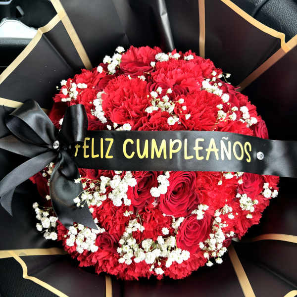 Red rose and carnation bouquet with white baby's breath and a birthday ribbon