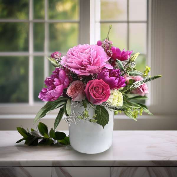 Pink and magenta flower arrangement in a white vase