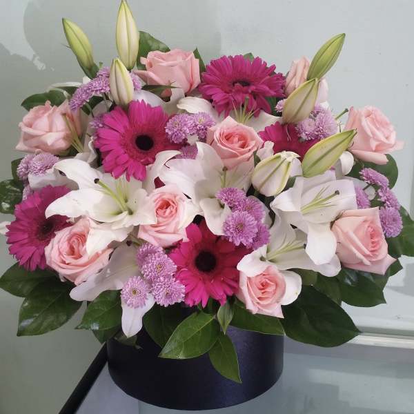 Pink roses, white lilies, and magenta gerbera daisies in a black box