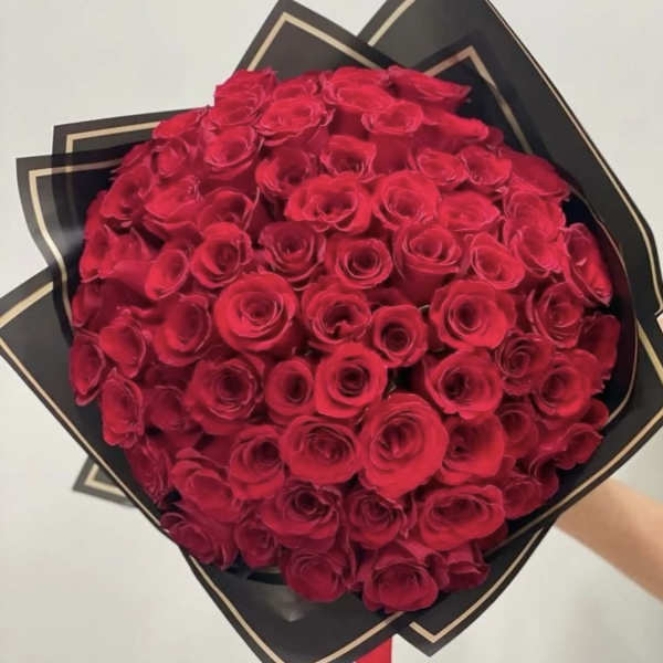 Large bouquet of red roses wrapped in black paper